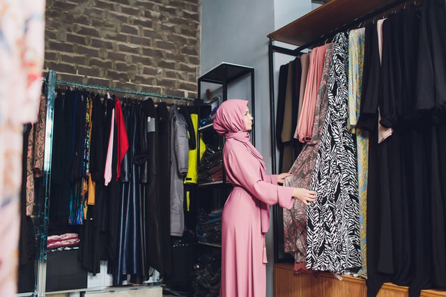 Arab Woman Choosing Dress In Shop