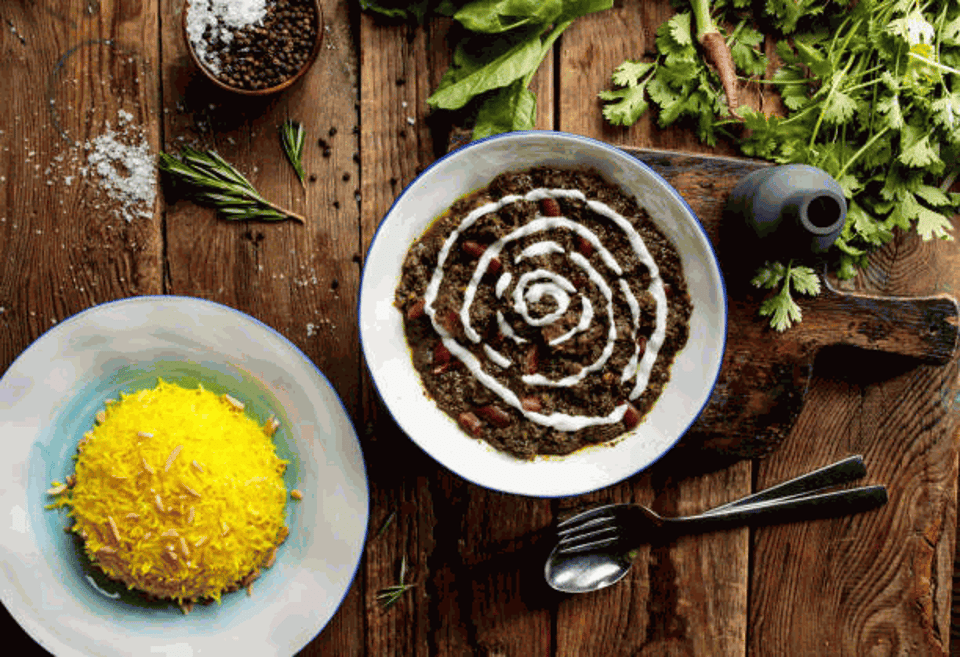 Ghormeh sabzi with rice served in a dish top view on wooden table